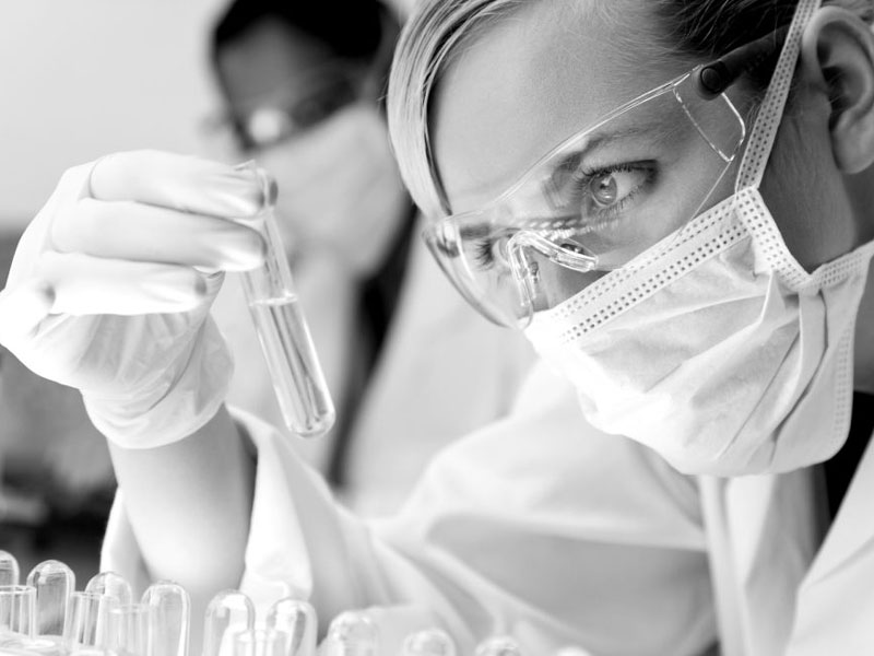 Female Scientific Research Team With Clear Solution In Laborator